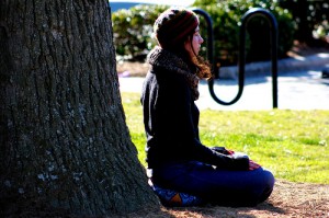 Girl meditating next to a tree